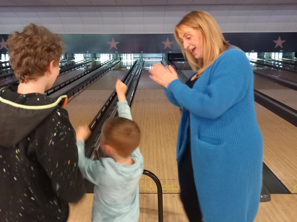 Two children and adult at bowling alley,